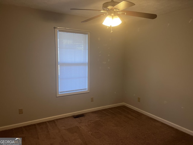 unfurnished room with carpet flooring, a ceiling fan, visible vents, and baseboards