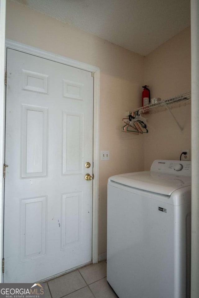 laundry room with washer / dryer, light tile patterned flooring, and laundry area