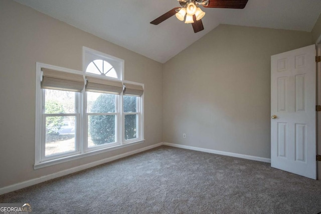 carpeted spare room featuring baseboards, lofted ceiling, and ceiling fan