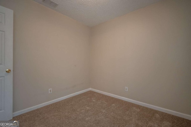 carpeted empty room with visible vents, baseboards, and a textured ceiling