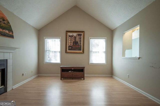 unfurnished living room featuring a wealth of natural light, light wood-style flooring, and a fireplace