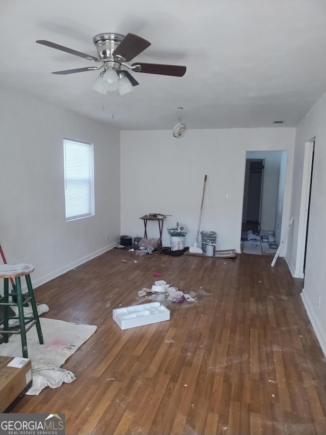 unfurnished living room with baseboards, a ceiling fan, and wood finished floors