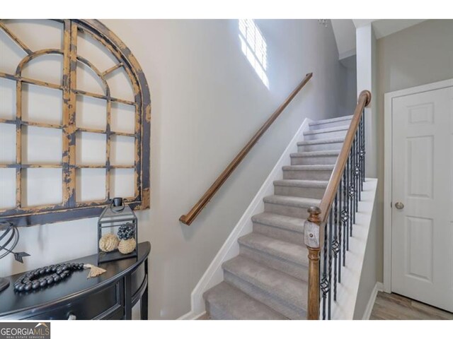 stairs with baseboards and wood finished floors