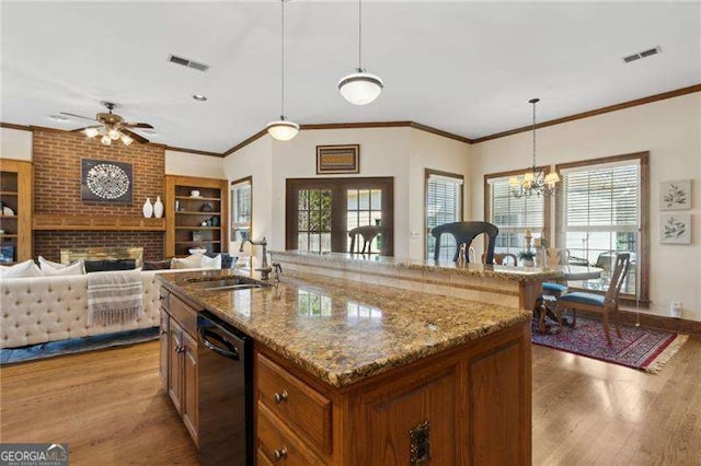 kitchen featuring light wood finished floors, visible vents, black dishwasher, and a sink