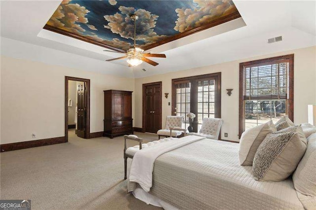 bedroom featuring baseboards, a raised ceiling, light colored carpet, and visible vents