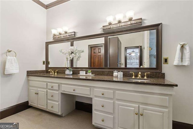 full bathroom with a sink, baseboards, and double vanity