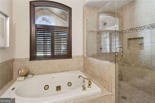 bathroom featuring a tub with jets and a shower stall