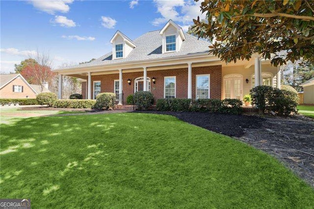 cape cod-style house featuring brick siding and a front lawn