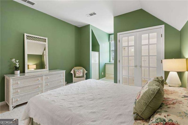 bedroom featuring visible vents, french doors, and vaulted ceiling