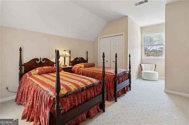 carpeted bedroom with lofted ceiling, baseboards, visible vents, and a closet