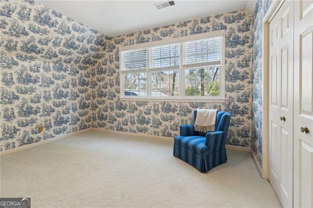 living area with visible vents, wallpapered walls, carpet, and baseboards