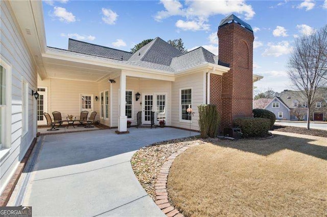 back of property featuring a patio and a chimney