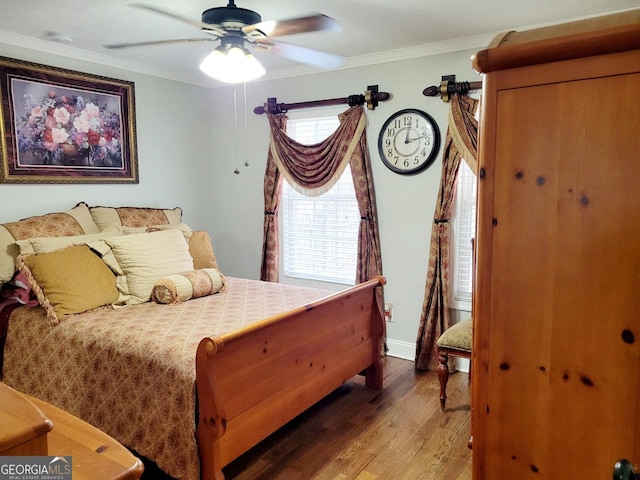 bedroom featuring ceiling fan, crown molding, baseboards, and wood finished floors