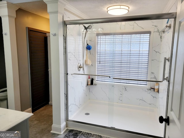 full bathroom featuring a marble finish shower, a textured ceiling, vanity, and ornate columns