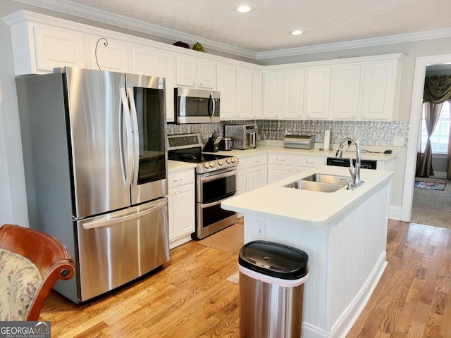 kitchen featuring white cabinets, appliances with stainless steel finishes, light wood-type flooring, and a sink