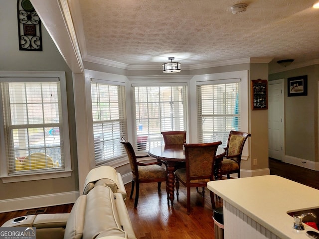 dining room featuring crown molding, dark wood-style floors, baseboards, and a textured ceiling