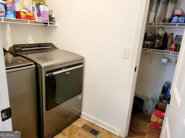 washroom with washing machine and clothes dryer, visible vents, laundry area, and baseboards