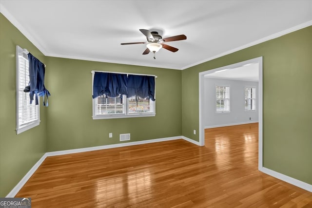 unfurnished room with ceiling fan, baseboards, wood finished floors, and ornamental molding