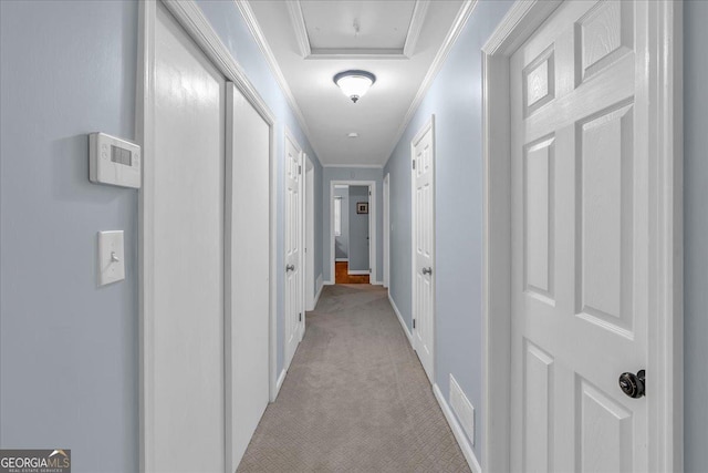 corridor featuring crown molding, light colored carpet, visible vents, and baseboards