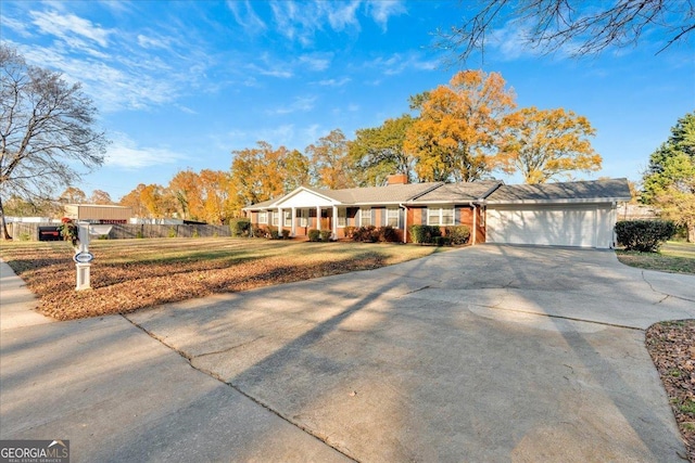 ranch-style house with a front lawn, fence, a chimney, driveway, and an attached garage