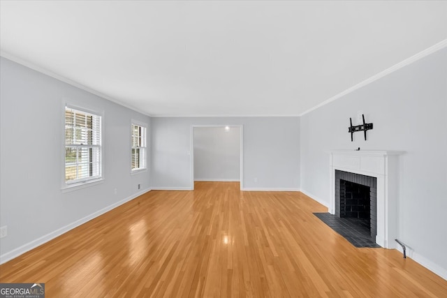 unfurnished living room featuring light wood-style flooring, a fireplace with flush hearth, baseboards, and ornamental molding