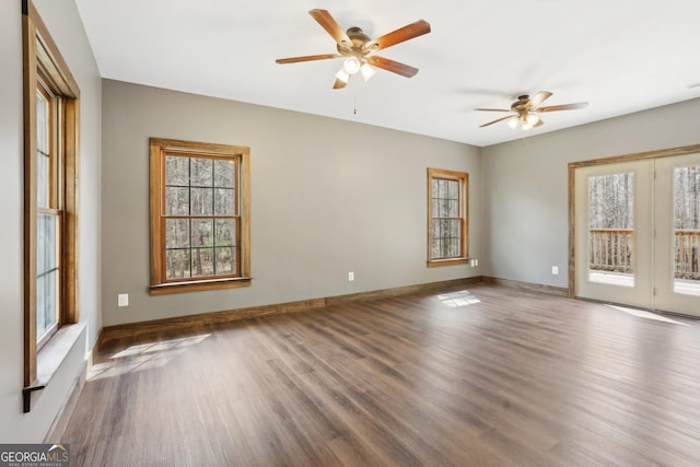 spare room with baseboards, a ceiling fan, and wood finished floors