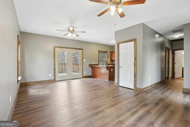 unfurnished living room with visible vents, baseboards, a ceiling fan, and wood finished floors