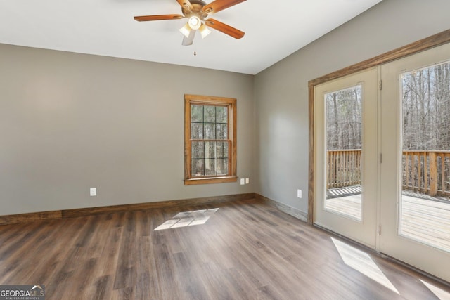 empty room featuring wood finished floors, a ceiling fan, and baseboards