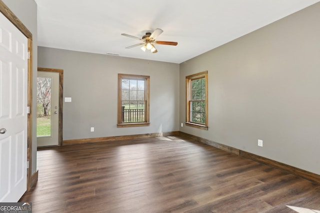 spare room with visible vents, baseboards, dark wood finished floors, and a ceiling fan