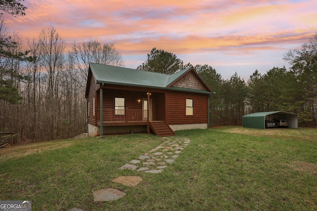 rustic home featuring driveway, a porch, a carport, faux log siding, and a lawn