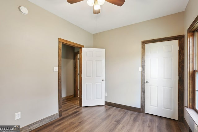 unfurnished bedroom featuring baseboards, wood finished floors, and a ceiling fan