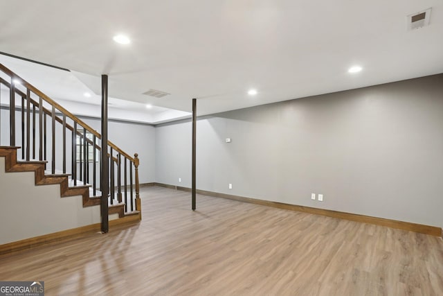 finished below grade area with recessed lighting, visible vents, baseboards, and light wood finished floors