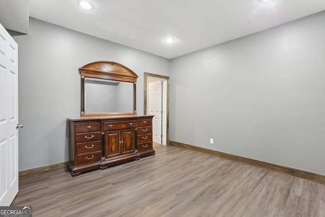 unfurnished bedroom with light wood finished floors, recessed lighting, and baseboards