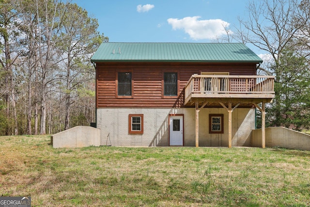 back of house featuring a deck, log veneer siding, metal roof, and a yard