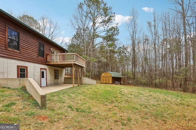 view of yard with an outbuilding, a shed, a patio, and a deck