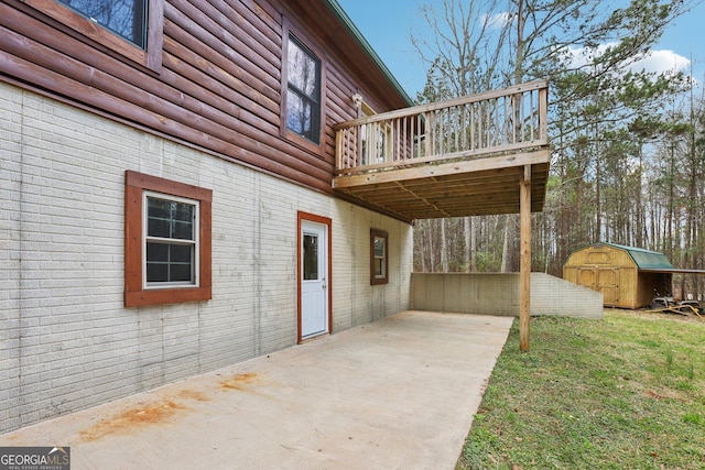 view of patio with an outbuilding, a storage unit, and a deck