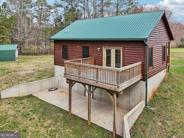 back of property featuring log veneer siding, a yard, a wooden deck, and a patio area