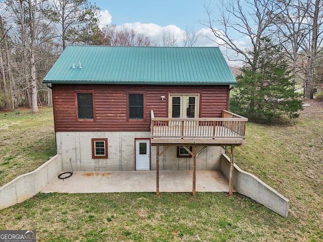 back of house with a yard, faux log siding, metal roof, and a patio