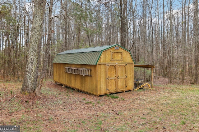 view of shed with a wooded view