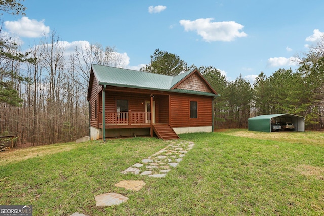 back of house with a lawn, covered porch, a carport, and faux log siding