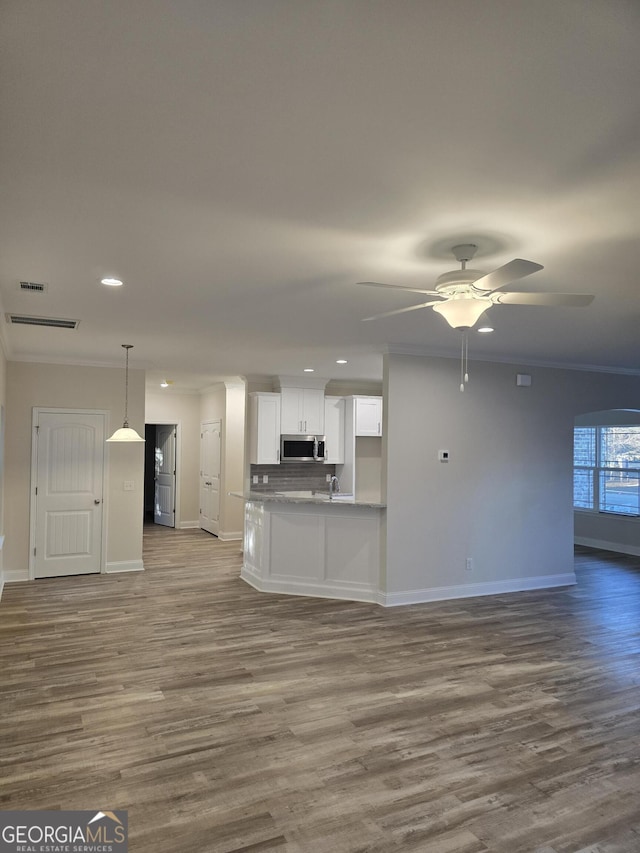 kitchen featuring stainless steel microwave, a ceiling fan, crown molding, and open floor plan