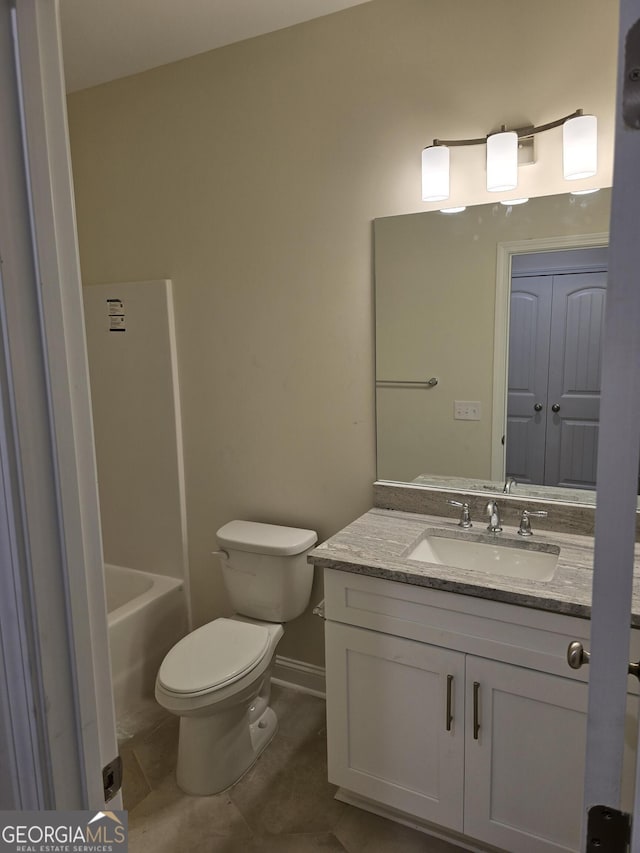 full bathroom with tile patterned floors, toilet, a bathing tub, baseboards, and vanity