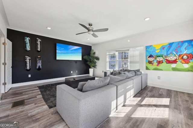 home theater room featuring visible vents, baseboards, a ceiling fan, and wood finished floors