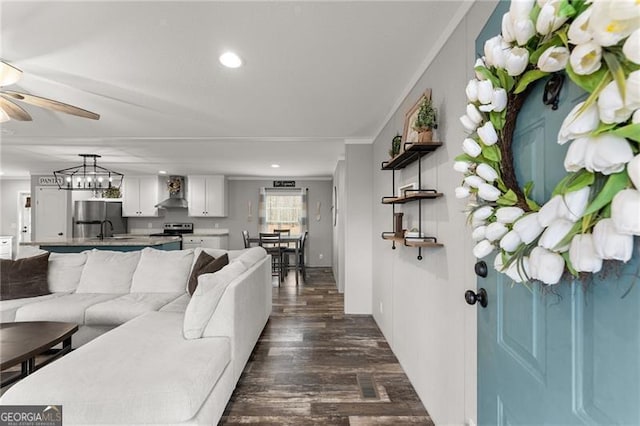 living area featuring recessed lighting, dark wood-style flooring, a ceiling fan, and ornamental molding
