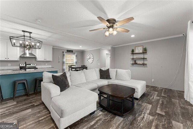 living area featuring ceiling fan with notable chandelier, crown molding, and dark wood-style floors