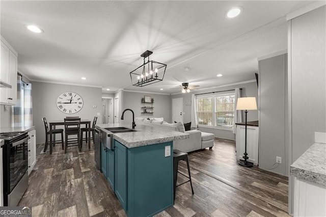 kitchen with dark wood-style floors, blue cabinetry, appliances with stainless steel finishes, and ornamental molding