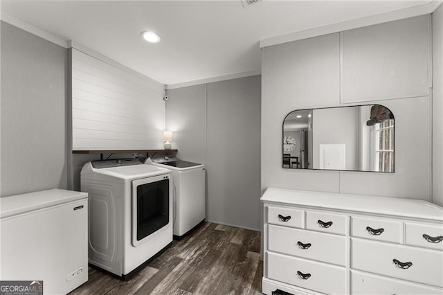 clothes washing area featuring washing machine and dryer, dark wood-style flooring, and laundry area