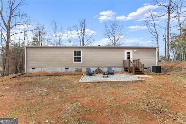 back of property featuring a fire pit and crawl space