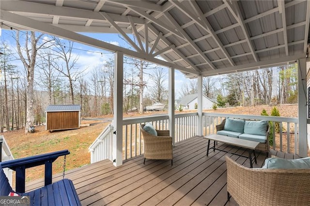 wooden deck featuring an outbuilding, a shed, and outdoor lounge area