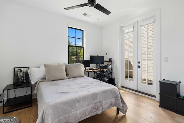 bedroom with visible vents, light wood finished floors, a ceiling fan, and access to outside